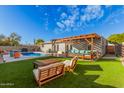 Inviting backyard oasis with a sparkling pool, pergola, and lush landscaping at 8301 E Crestwood Way, Scottsdale, AZ 85250