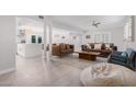 Bright and airy living room with leather sofas, a large TV, and tile floors at 8301 E Crestwood Way, Scottsdale, AZ 85250