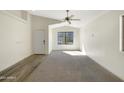 Spacious living room with neutral walls, carpet flooring, and a ceiling fan at 5850 E Everhart Ln, Florence, AZ 85132