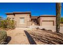 Tan two-story house with a three-car garage and desert landscaping at 11270 E Quarry Trl, Scottsdale, AZ 85262