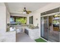 Outdoor kitchen features granite countertops, stainless steel appliances, and a ceiling fan at 28614 N Sunset Dr, San Tan Valley, AZ 85143