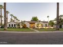 Charming Spanish-style home with a manicured lawn, beautiful landscaping, and tall palm trees at 1817 Palmcroft Ne Way, Phoenix, AZ 85007