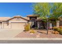 Two-car garage and front entry of a single-story house with desert landscaping at 8310 E Greenview Dr, Gold Canyon, AZ 85118