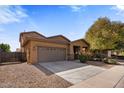 Single-story house with a two-car garage and nicely landscaped front yard at 1695 E Mia Ln, Gilbert, AZ 85298