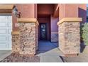 Stone columns frame the entry to this home with a black door at 964 W Saguaro Ln, San Tan Valley, AZ 85143