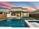 Two-story home with a sparkling pool and spa, lush landscaping, and a covered patio at 19834 W Rancho Dr, Litchfield Park, AZ 85340