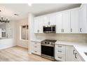 Modern white kitchen with stainless steel appliances and quartz countertops at 10802 E Secret Canyon Rd, Gold Canyon, AZ 85118
