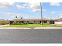 Ranch style home with well-manicured lawn and mature trees at 11133 W Cameo Dr, Sun City, AZ 85351