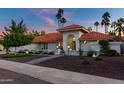 Single story home with tile roof, arched entry, and landscaped yard at 8643 E San Jacinto Dr, Scottsdale, AZ 85258