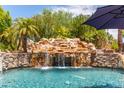 Relaxing pool area with waterfall and lush landscaping at 11305 S 195Th Dr, Buckeye, AZ 85326