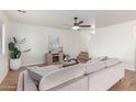 Bright living room featuring a sofa, coffee table, and fireplace at 42802 W Hillman Dr, Maricopa, AZ 85138