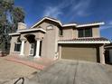 Two-story house with a tan stucco exterior, a large garage, and a landscaped front yard at 920 E Annette Dr, Phoenix, AZ 85022