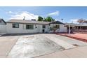 White brick ranch house with a spacious front yard and red brick driveway at 8151 W Clarendon Ave, Phoenix, AZ 85033
