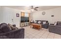 Living room with two dark gray sofas, a coffee table, and a large TV at 8151 W Clarendon Ave, Phoenix, AZ 85033