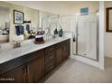 Spa-like bathroom with double sinks, a large mirror, and a walk-in shower at 20640 N Confetti Ct, Maricopa, AZ 85138