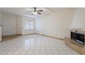 Bright living room with tile floors, fireplace, and ceiling fan at 1446 E Grovers Ave # 13, Phoenix, AZ 85022