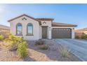 Single-story home with a two-car garage and desert landscaping at 453 E Wiley Way, Casa Grande, AZ 85122