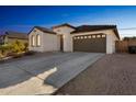 Charming one-story home with a brown garage door and desert landscaping at 453 E Wiley Way, Casa Grande, AZ 85122