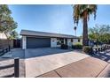 Modern home with gray garage door and long driveway at 8319 E Palm Ln, Scottsdale, AZ 85257