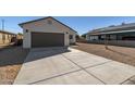 Newly built home with a gray garage door and a concrete driveway at 255 W Wilson Ave, Coolidge, AZ 85128