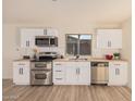 Modern kitchen with white shaker cabinets, stainless steel appliances, and butcher block countertops at 4601 W Wilshire Dr, Phoenix, AZ 85035