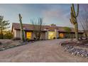 Front view of a ranch-style home with a curved driveway and desert landscaping at 36444 N Stardust Ln, Carefree, AZ 85377