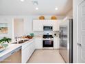 Modern kitchen with white cabinets, stainless steel appliances, and quartz countertops at 38090 N Longbow Way, San Tan Valley, AZ 85140