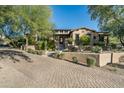 Luxury home exterior with a brick driveway at 19481 N 98Th Pl, Scottsdale, AZ 85255