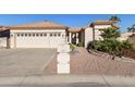 Tan two-car garage home with terracotta tile roof and desert landscaping at 25418 S Spring Creek Rd, Sun Lakes, AZ 85248