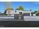 Modern house with gray garage and rock wall at 4331 W Port Au Prince Ln, Glendale, AZ 85306