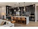 Modern kitchen with dark cabinetry, an island, and stainless steel appliances at 1417 E Cherrywood Pl, Chandler, AZ 85249
