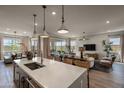 Open kitchen with island, modern light fixtures and a view to the living room at 1417 E Cherrywood Pl, Chandler, AZ 85249