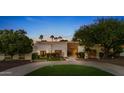 Modern home with stone accents, lush landscaping and a circular driveway at 10540 E Larkspur Dr, Scottsdale, AZ 85259