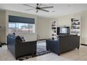 Living room featuring two sofas, a built-in shelving unit, and a large TV at 3925 S 6Th Ave, Phoenix, AZ 85041