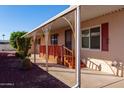Covered porch with decorative metal railings and wooden steps leading to the entrance at 9302 E Broadway Rd # 9, Mesa, AZ 85208