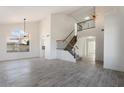 Bright living room with high ceilings, stylish light fixture, and gray tile floors at 1207 N Velero St, Chandler, AZ 85225