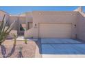 Tan stucco home with a two-car garage and desert landscaping at 8753 E Greenview Dr, Gold Canyon, AZ 85118