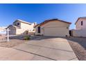 House exterior featuring a two-car garage and well-maintained landscaping at 9545 W Clara Ln, Peoria, AZ 85382