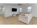 Bright living room featuring a large sectional sofa and flat-screen TV at 44395 W Bailey Dr, Maricopa, AZ 85138