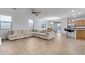 Spacious living room with an open floor plan and L-shaped sectional sofa at 44395 W Bailey Dr, Maricopa, AZ 85138