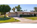 Ranch style home with attached garage and manicured lawn at 10621 W Oakmont Dr, Sun City, AZ 85351