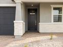 Front door with stone accents, a black door, and a covered entryway at 33 S 176Th Dr, Goodyear, AZ 85338