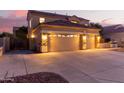 Two-story house with a tan facade, three-car garage, and landscaped yard at 13029 W Campbell Ave, Litchfield Park, AZ 85340