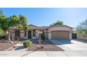 Tan house exterior with a two-car garage and landscaping at 7585 W Tumblewood Dr, Peoria, AZ 85382