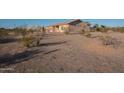 Desert landscape behind a one-story house with a large shop in the distance at 9068 N Cox Rd, Casa Grande, AZ 85194