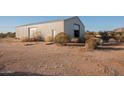 Large metal shop building with a roll-up door and side entry door at 9068 N Cox Rd, Casa Grande, AZ 85194