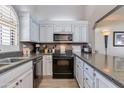 L-shaped kitchen with white cabinets and granite countertops at 6138 N 28Th St, Phoenix, AZ 85016