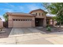 Single-story home with tan stucco exterior, a two-car garage, and desert landscaping at 20823 S 185Th Way, Queen Creek, AZ 85142