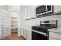 Stainless steel appliances and white cabinetry in a well-lit kitchen at 9911 S Caballo Dr, Apache Junction, AZ 85120