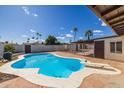 Inviting kidney-shaped pool with diving board in backyard at 3415 W Willow Ave, Phoenix, AZ 85029